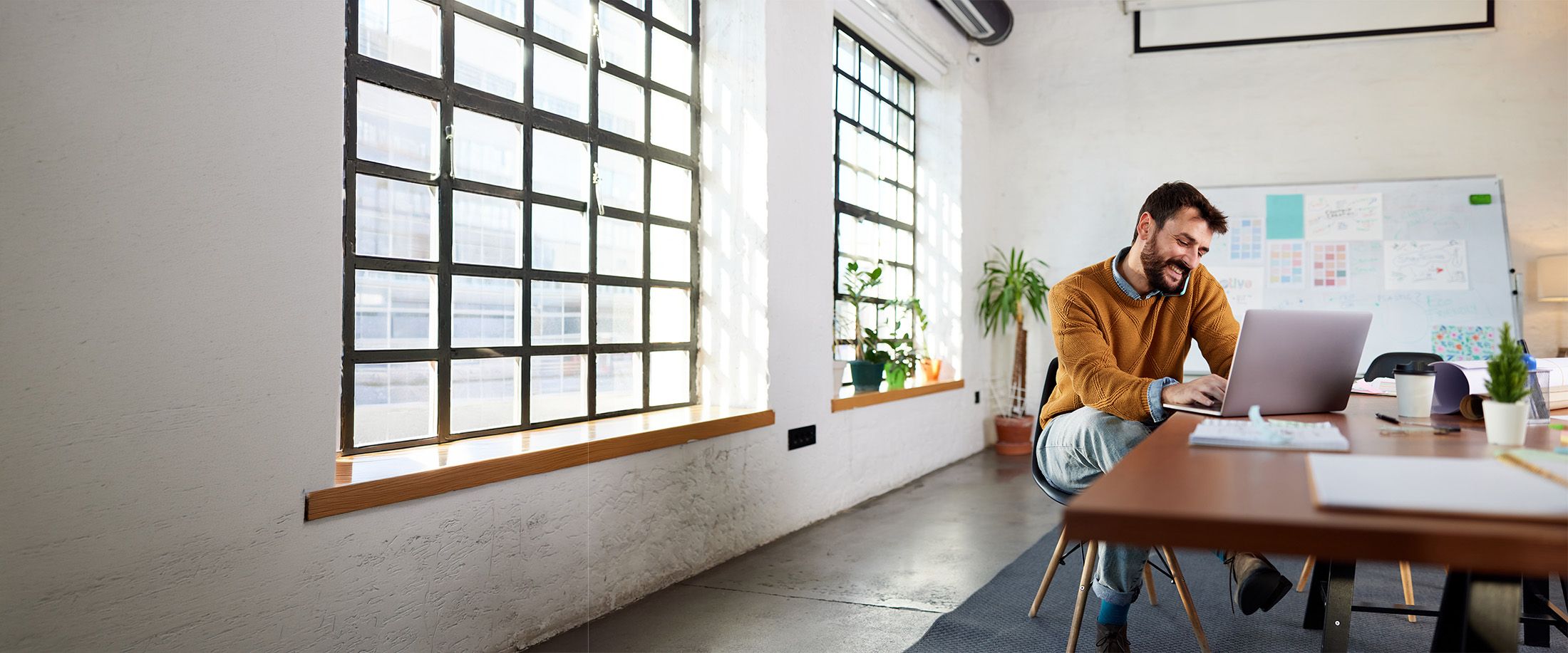 A man working on his laptop in a bright office