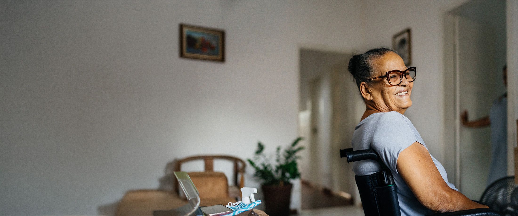 A smiling woman in a wheelchair at home