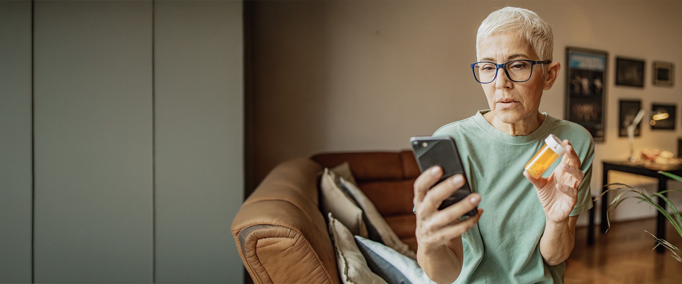 A woman checking her prescription bottle against her phone