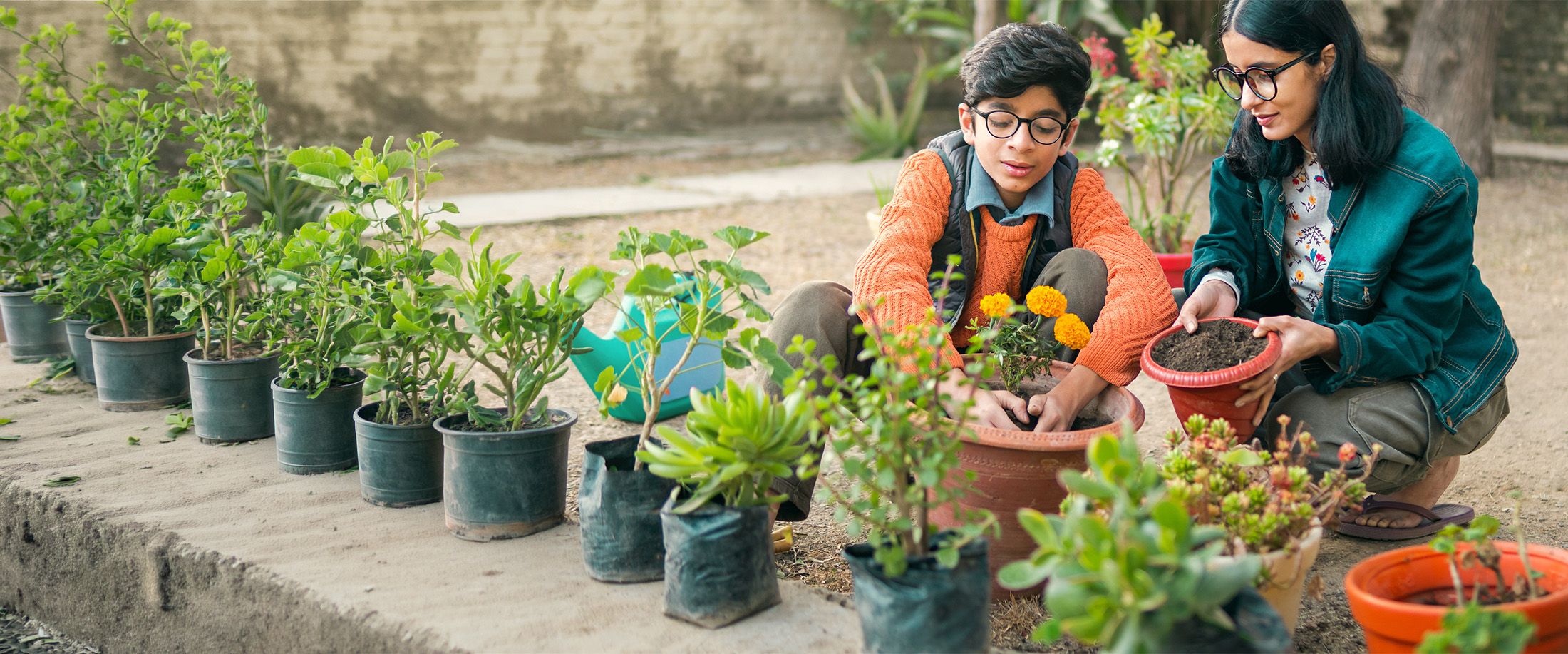A mother and son planting flowers in the garden