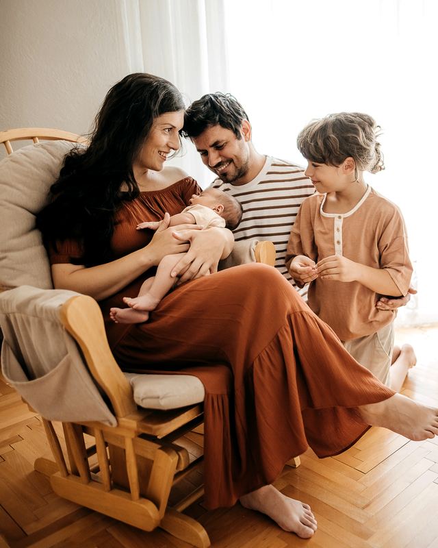 A family at home with their newborn and older child