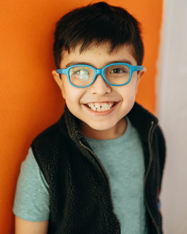 A boy wearing glasses at home