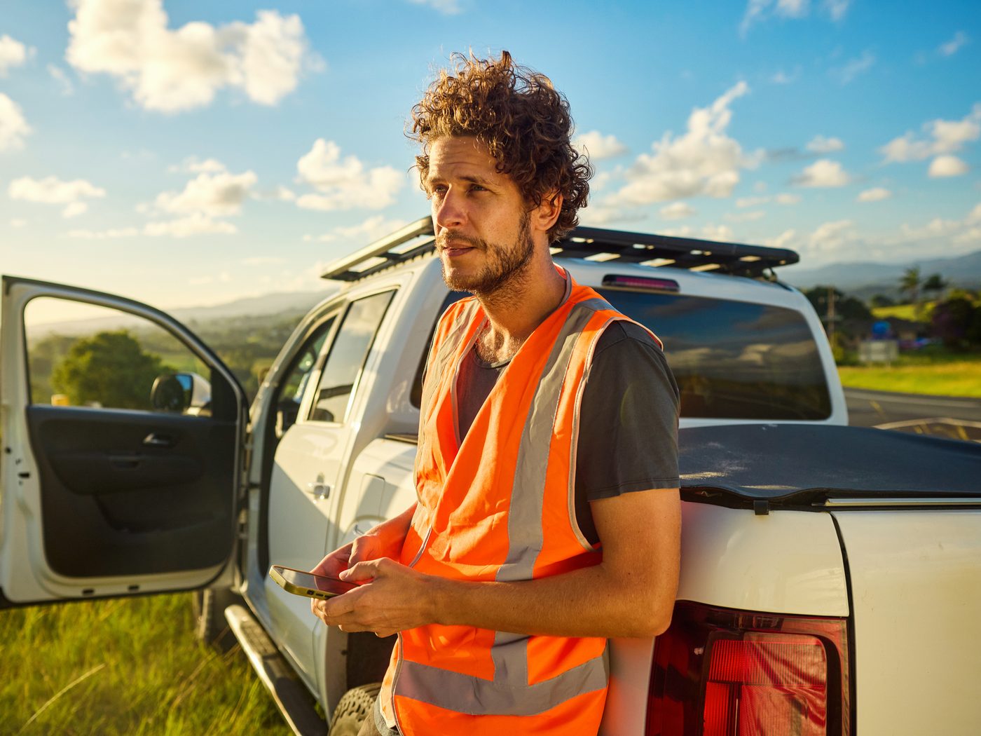 A Sunland field worker checking his phone beside a work truck